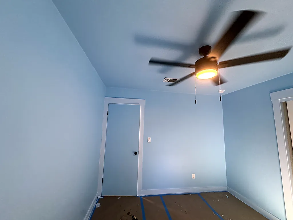 Bedroom repainted in a soft blue with white ceiling and trim in Destin, Florida
