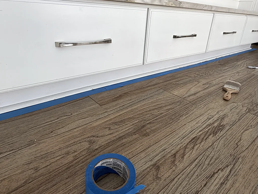 Built-in drawers masked with painter's tape along the floor before finishing in a Destin, Florida home