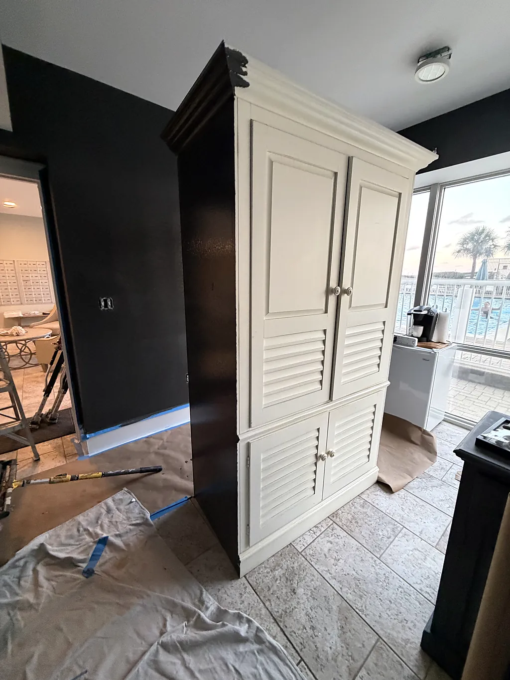 Cream cabinet and surrounding walls part-way through preparation in a Gulf-front Destin condo