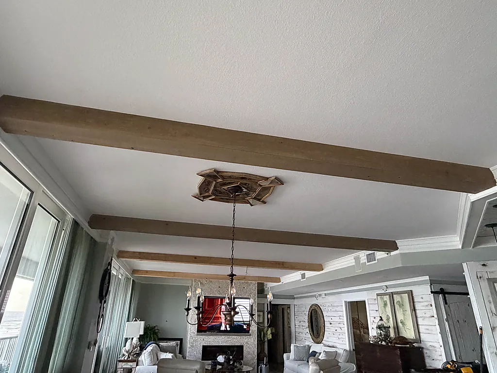 Finished white ceiling with fitted timber beams in a Gulf-front living room in Destin, Florida