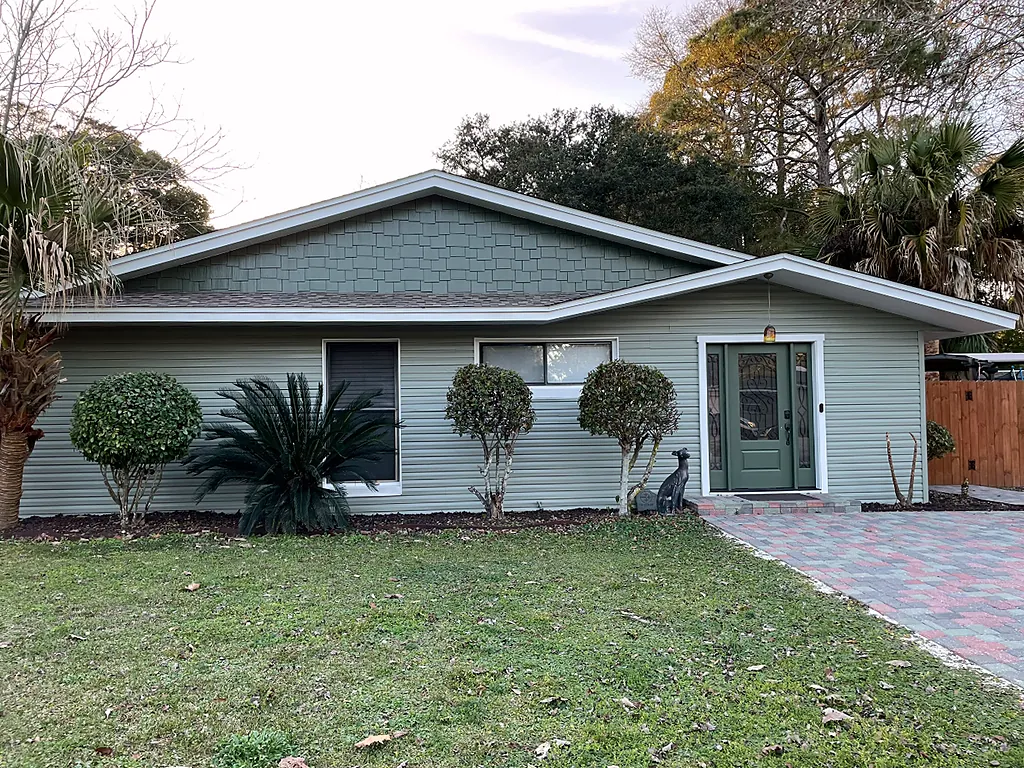 Ranch home in Destin, Florida finished in soft sage green with white fascia and trim after a full exterior repaint