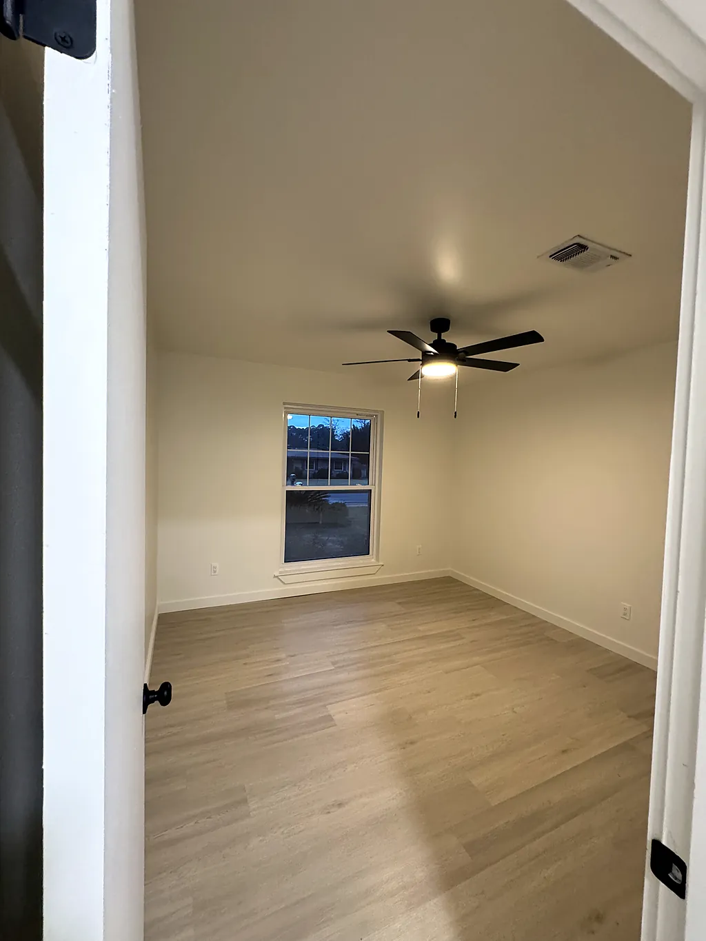 A corner of a repainted room showing fresh wall color against white window trim